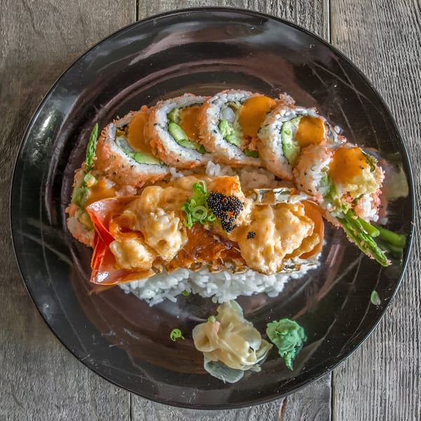 Lobster tail sushi with black caviar, served with rice, pickled ginger, and wasabi.
